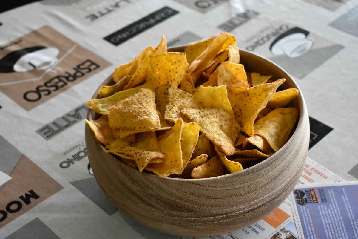 Tortilla chips piled in a wooden bowl